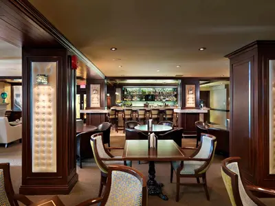 a restaurant with a table and chairs and a bar at Chateau Victoria Hotel & Suites in Victoria
