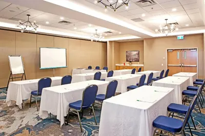 a conference room with tables and chairs and a whiteboard at Holiday Inn Hotel & Suites - Calgary Airport North by IHG in Calgary