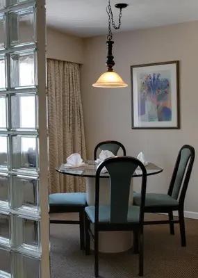 a dining room with a table and chairs at Rosellen Suites at Stanley Park in Vancouver