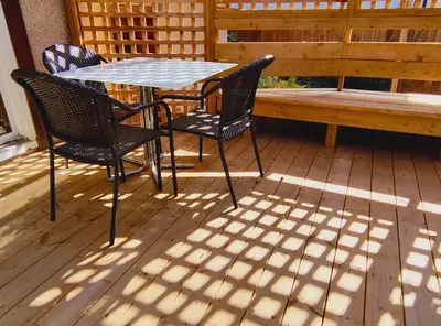 a table and chairs on a deck with a bench at U of A Homestay, Trails & Whyte Ave in Edmonton