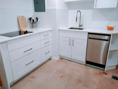 a white kitchen with a sink and a dishwasher at U of A Homestay, Trails & Whyte Ave in Edmonton