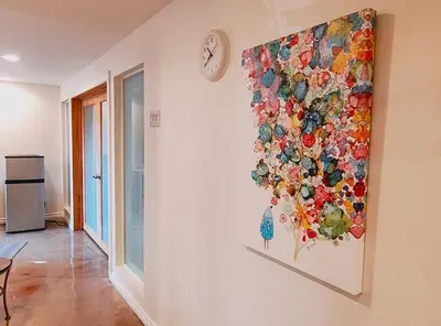 a painting of flowers on a wall with a clock at U of A Homestay, Trails & Whyte Ave in Edmonton