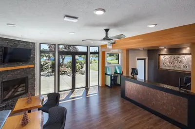 a living room with a fireplace and a tv at Inn on Long Lake in Nanaimo