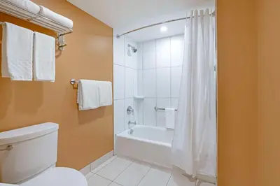 a bathroom with a tub and a toilet and a shower at Best Western Plus Emerald Isle Hotel in Sidney