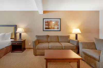 a hotel room with a couch and a bed at Best Western Plus Emerald Isle Hotel in Sidney