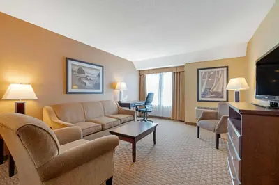 a living room with a couch and a tv at Best Western Plus Emerald Isle Hotel in Sidney