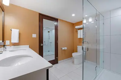 a bathroom with a sink and a shower and a toilet at Best Western Plus Emerald Isle Hotel in Sidney