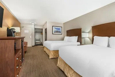 a hotel room with two beds and a flat screen tv at Best Western The Westerly Hotel in Courtenay