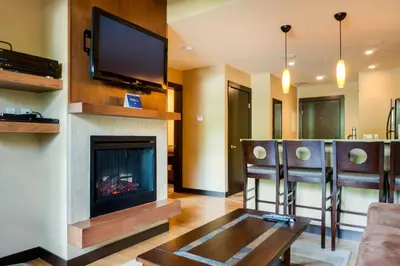 a living room with a fireplace and a flat screen tv at Silver Creek Lodge in Canmore