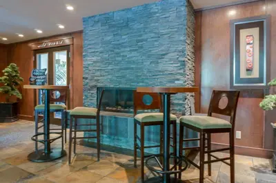 a bar with stools and a stone wall at Silver Creek Lodge in Canmore