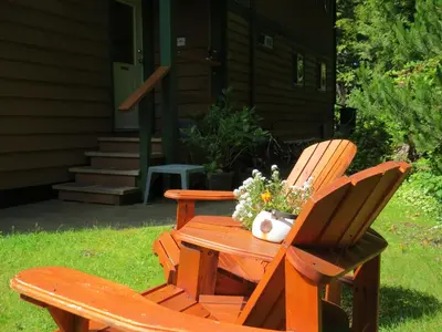 a wooden bench with a vase of flowers on it at Summerhill Guest House in Tofino