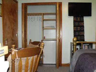 a room with a room with a refrigerator and a ladder at Summerhill Guest House in Tofino