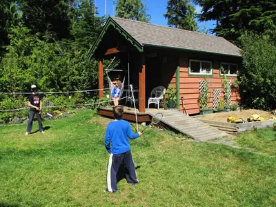 two children playing in a yard with a racket at Summerhill Guest House in Tofino