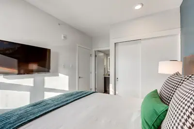 a bedroom with a bed and a flat screen tv at Marquee on 16th in Calgary