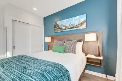 a bedroom with a bed with a blue accent wall at Marquee on 16th in Calgary