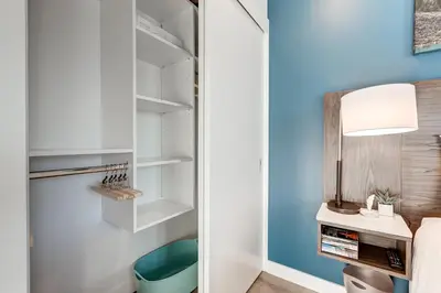 a bedroom with a blue wall and a desk and a bed at Marquee on 16th in Calgary