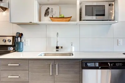 a kitchen with a sink and a microwave at Marquee on 16th in Calgary