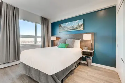 a bedroom with a large bed and a blue wall at Marquee on 16th in Calgary