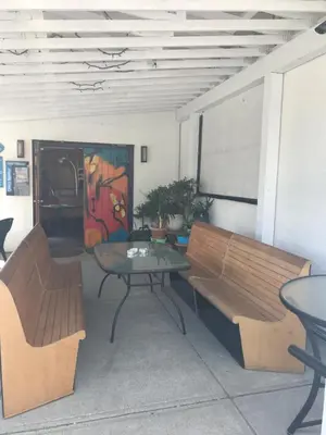 a room with benches and a table and a painting at Char's Landing Hostel in Port Alberni