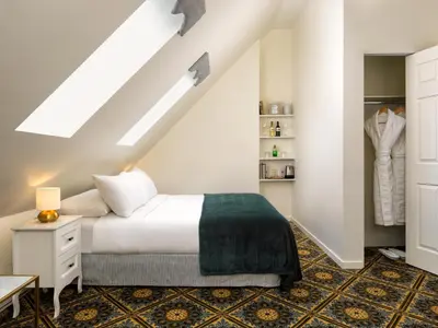 a bedroom with a white bed and a closet at Pendray Inn and Tea House in Victoria