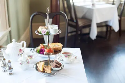 a three tiered tray of pastries and tea cups on a table at Pendray Inn and Tea House in Victoria