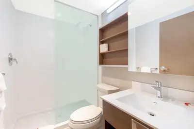 a white bathroom with a toilet and a sink at Microtel Inn & Suites by Wyndham Fort McMurray in Fort McMurray