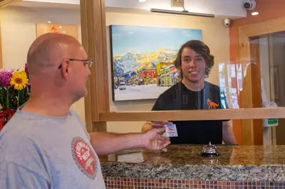 a man holding a credit card in front of a mirror at Fernie Fox Hotel in Fernie