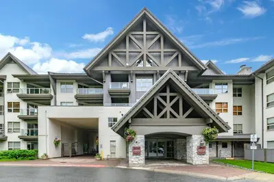 a large white building with a pointed roof at The Best Top Floor Ski-in/Ski-out at the Aspens in Whistler