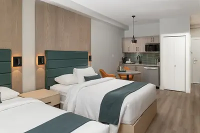 a hotel room with two beds and a kitchen at Harrison Beach Hotel in Harrison Hot Springs