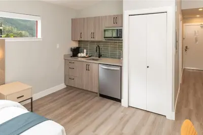 a kitchen with white cabinets and a counter top at Harrison Beach Hotel in Harrison Hot Springs
