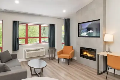 a living room with a couch and a fireplace at Harrison Beach Hotel in Harrison Hot Springs