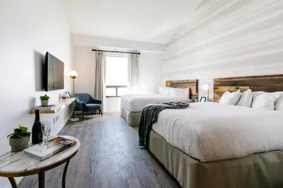 a hotel room with two beds and a table at Glacier View Lodge in Sunwapta