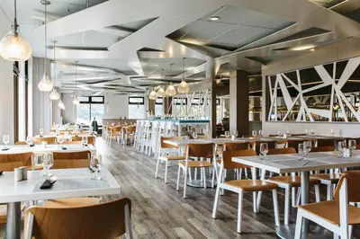 a restaurant with white tables and chairs at Glacier View Lodge in Sunwapta