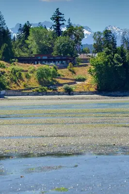 a large body of water with a house in the background at Sunrise Ridge Waterfront Resort in Parksville