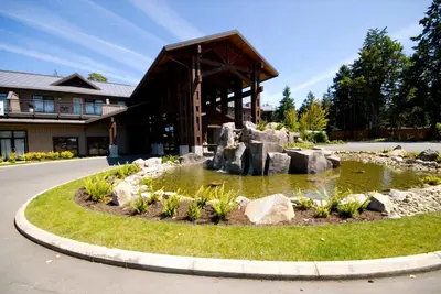 a pond with rocks in front of a building at Sunrise Ridge Waterfront Resort in Parksville