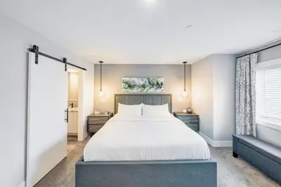 a bedroom with a large bed and a window at Sunrise Ridge Waterfront Resort in Parksville
