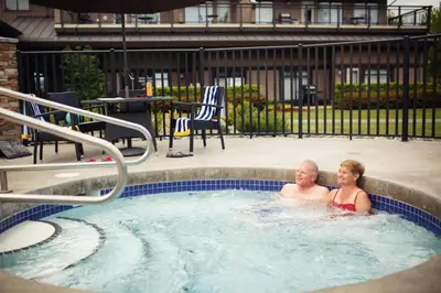 a man and a woman in a hot tub at Sunrise Ridge Waterfront Resort in Parksville