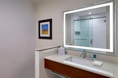 a bathroom with a sink and a large mirror at Four Points by Sheraton Grande Prairie in Grande Prairie