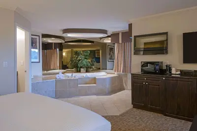 a large bathroom with a tub and a sink at Travelodge by Wyndham Kamloops Mountview in Kamloops