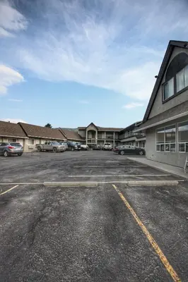 a parking lot with cars parked in front of a building at Best Budget Inn & Suites Kamloops in Kamloops