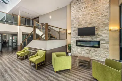 a lobby with a table and chairs and a brick wall at Quality Inn in Kamloops