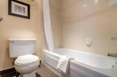 a bathroom with a white toilet and a bath tub at Quality Inn in Kamloops