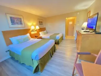 a hotel room with two beds and a television at Travelodge by Wyndham Edmonton East in Edmonton
