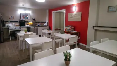 a restaurant with white tables and white chairs at Travelodge by Wyndham Edmonton East in Edmonton