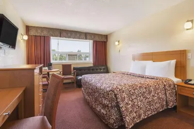a hotel room with a bed and a desk at Travelodge by Wyndham Edmonton East in Edmonton