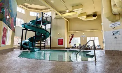 a indoor swimming pool with a slide in a building at Super 8 by Wyndham Edmonton South in Edmonton