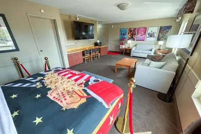 a bedroom with a bed and a living room at Super 8 by Wyndham Edmonton South in Edmonton