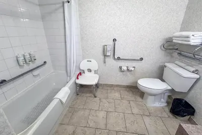 a bathroom with a toilet and a tub and a sink at Ramada by Wyndham Sherwood Park in Sherwood Park