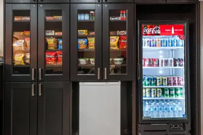 a refrigerator filled with lots of drinks and soda at Ramada by Wyndham Sherwood Park in Sherwood Park