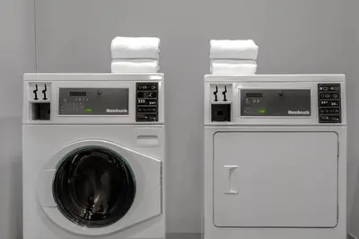 two white washing machines sitting next to each other at Ramada Plaza by Wyndham Calgary Downtown in Calgary
